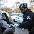 A French police officer checks that motorists are carrying the correct mobility document at the Place d'Italie in Paris, on March on 18, 2020. A strict lockdown requiring most people in France to remain at home came into effect at midday on March 17, 2020