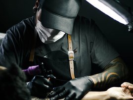 man tattooing arm/pexels