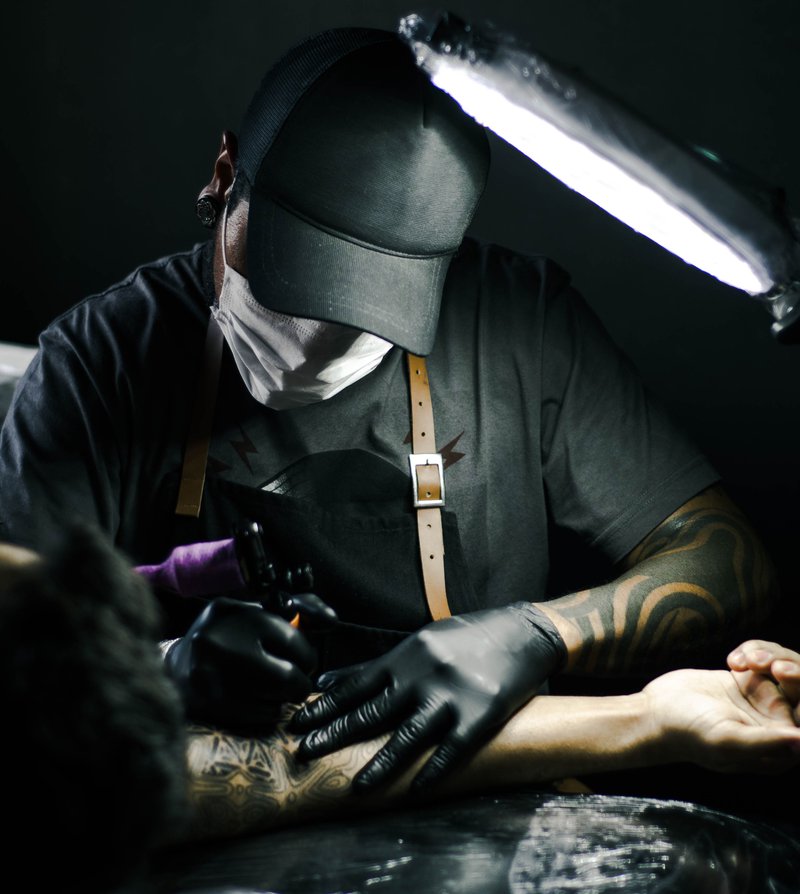 man tattooing arm/pexels