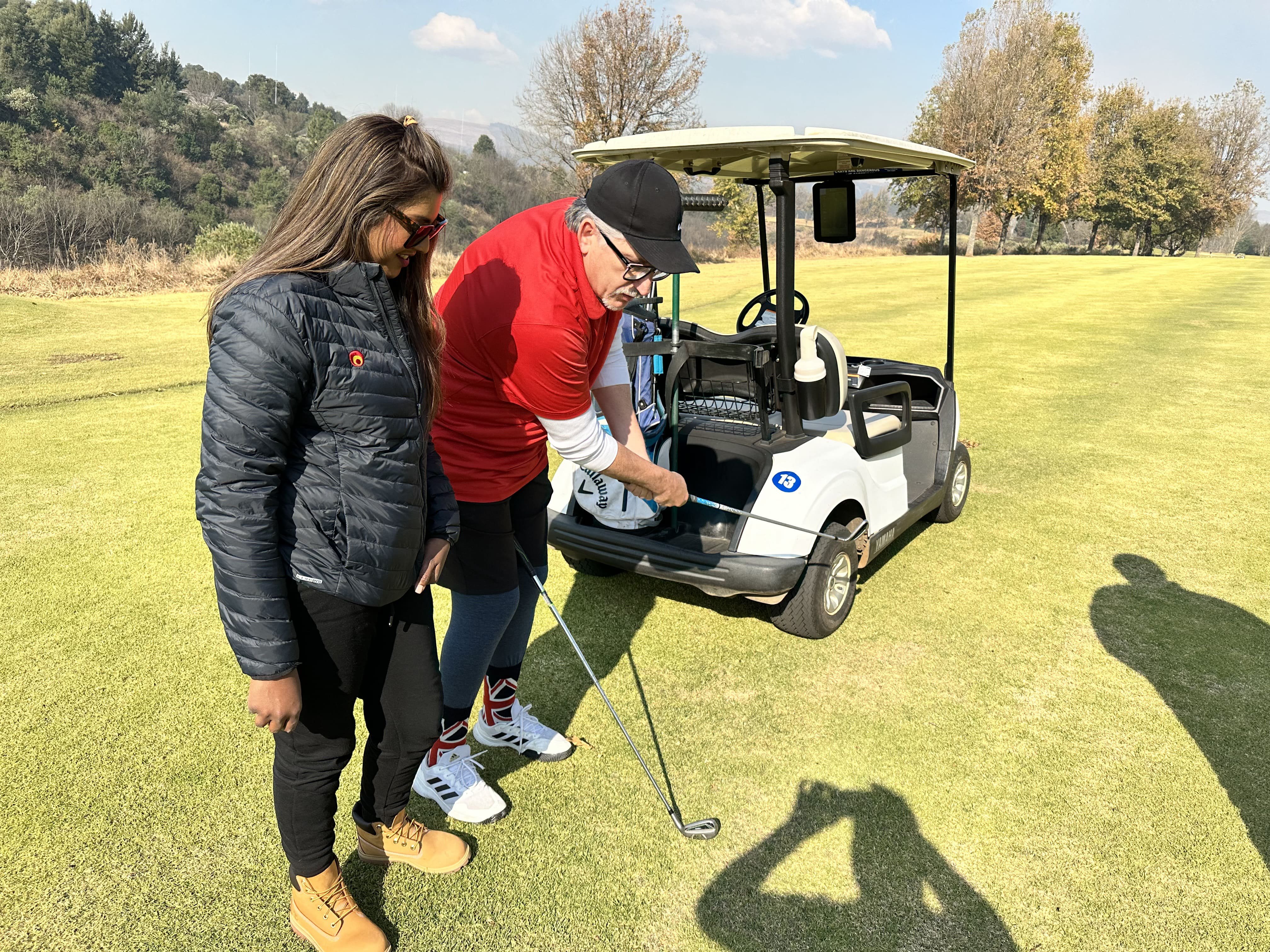 Darren teaching Carmen on how to play golf during their time at Champagne Sports Resort.