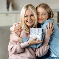 Mother and daughter hugging with gift in hand iStock