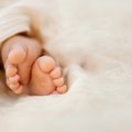 Newborn baby feet closeup on soft cream wrap