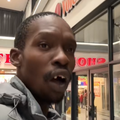 A black man singing at the mall