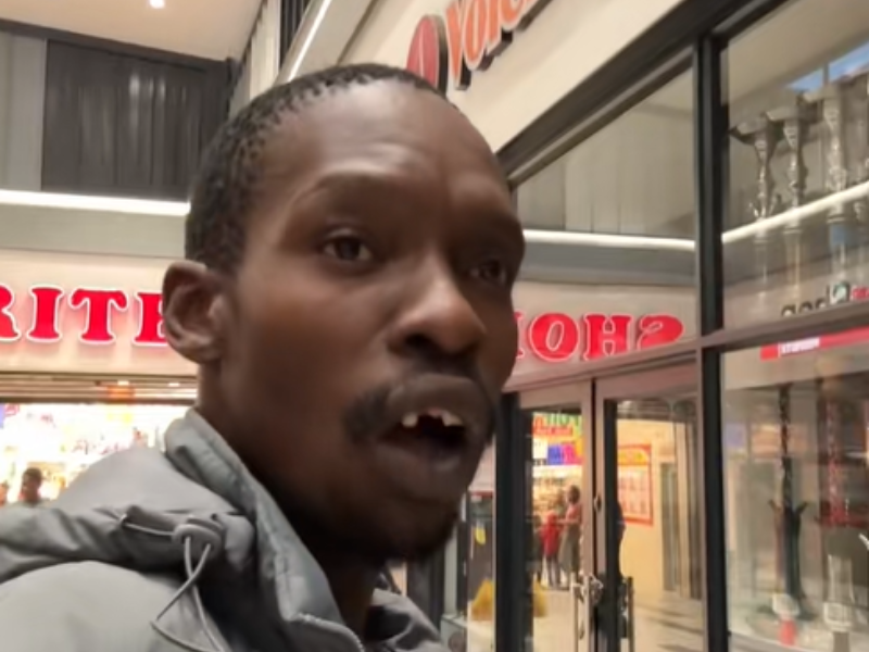 A black man singing at the mall