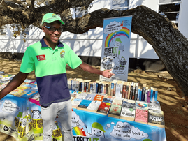 A bookseller from StreetLit booksellers standing at his book stall