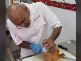 A butcher brushing the teeth of a cut sheephead