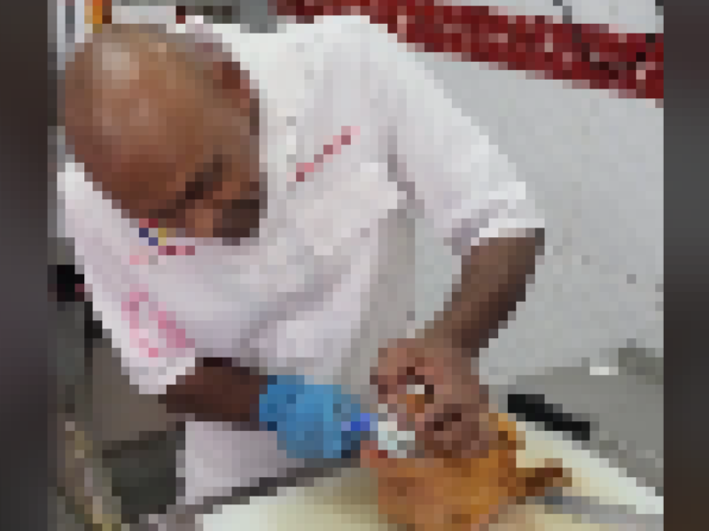 A butcher brushing the teeth of a cut sheephead