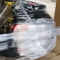 A car is covered in cling wrap parked inside a parking lot