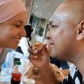 A couple eat off the same piece of chicken at a restaurant