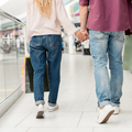 A couple holding hands at a mall while shopping