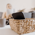 Black phone in a basket on a table