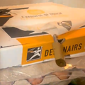 A Debonairs pizza box inside a fridge with a lock