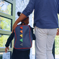 A father escorts his daughter into school doorway