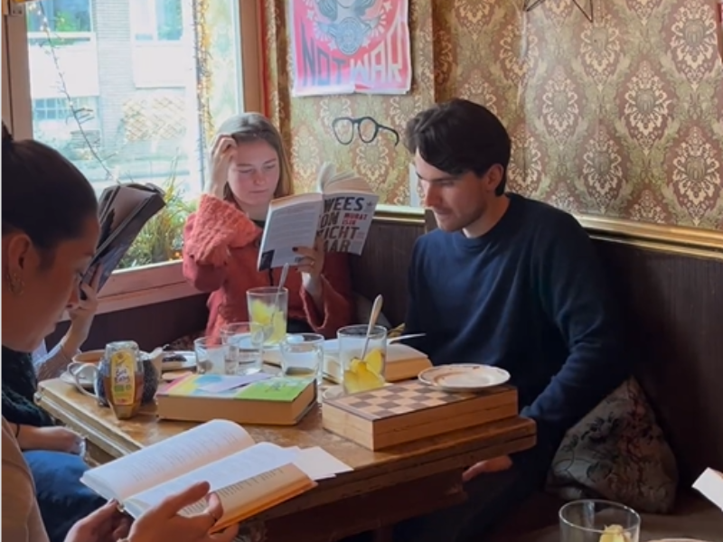A group of people reading at a coffee shop in Amsterdam