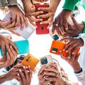 A group of people using their smartphones in a huddle