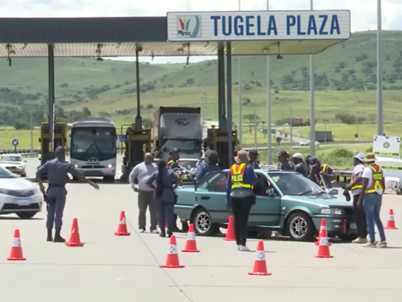 A group of police officials at a roadblock near a toll plaza