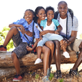 A happy black family sitting on a log while hiking
