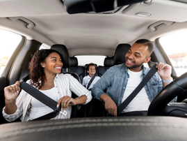 A happy coloured family enjoying a car ride