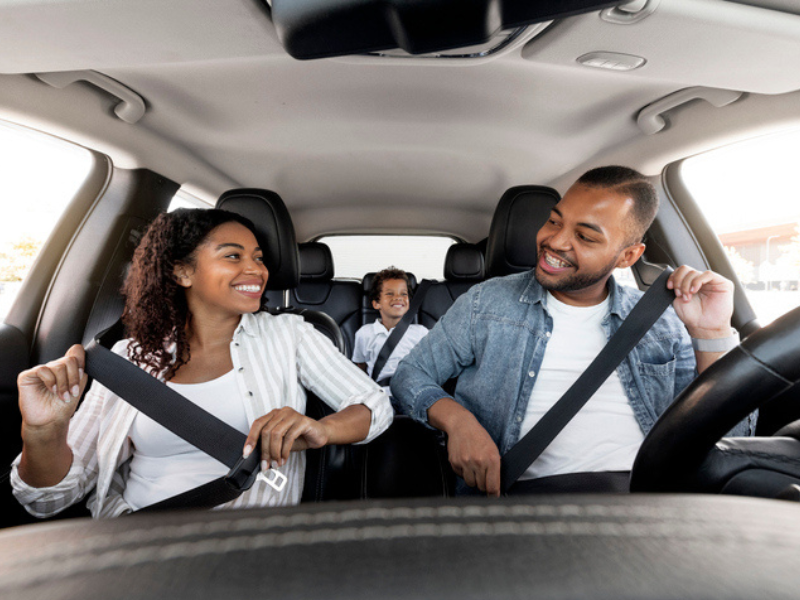 A happy coloured family enjoying a car ride