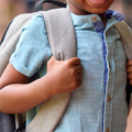 A kindergarten school pupil holding his backpack