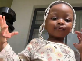 A little girl posing with mop strands on her hair