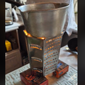 A makeshift stovetop made with candles and a grater