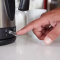 A man flicks the switch to boil a kettle