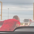 A man leans into a car window to chat to a motorist at the toll plaza