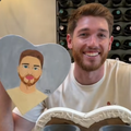A man posing with a painted portrait of himself