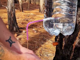 A man washing his hands using a makeshift water tap