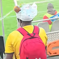 A man wearing  a baby nappy on his head at a football match