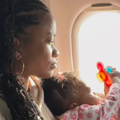 A mother sits on a flight with her baby on her lap