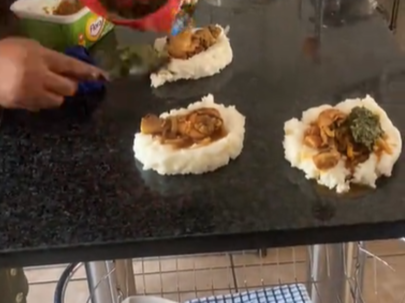A person dishing out food on the granite kitchen counter tops