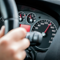 A person drives a car at high speed on the speedometer