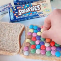 A person making a sandwich with chocolate buttons