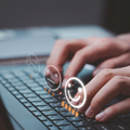 A person's hands typing on a laptop