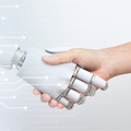 A robot and human handshake indicating artificial intelligence and digital transformation
