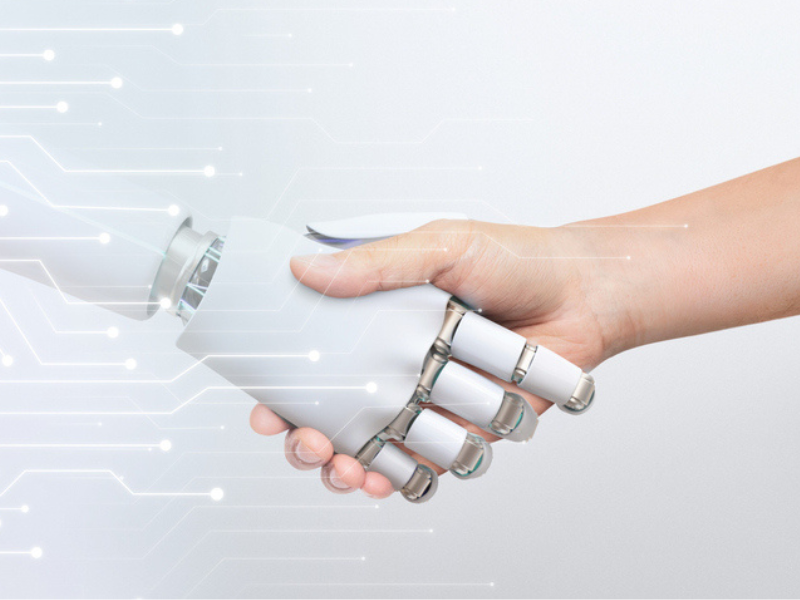 A robot and human handshake indicating artificial intelligence and digital transformation