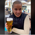A South African woman drinking a beer at an outdoor restaurant