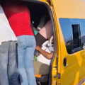A taxi is overloaded with passengers standing