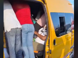 A taxi is overloaded with passengers standing