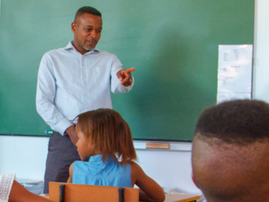 A teacher engages with students in classroom during the lesson
