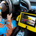 A toddler drives a Ferrari using a camera