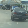 A vehicle driving on a road without a fourth tyre