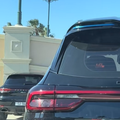 A view of a Chery and a Porsche parked at a parking lot