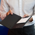 A waiter holds a the bill for customer out