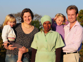 A white South African family standing with their domestic helper