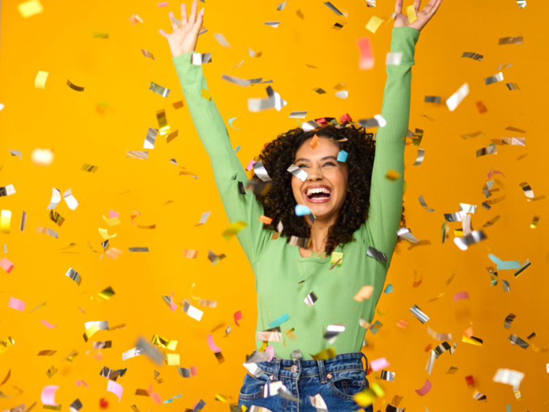 A woman celebrating her big win with confetti in the air
