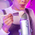 A woman creating ASMR sound on a microphone with a brush