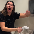 A woman is shocked while holding a kettle